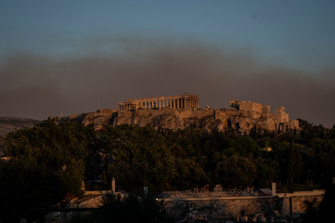 Ο καπνός από μια φωτιά σκέπασε μέρος του αθηναϊκού ουρανού καθώς φαίνεται πίσω από τον αρχαίο λόφο της Ακρόπολης με τον ναό του Παρθενώνα