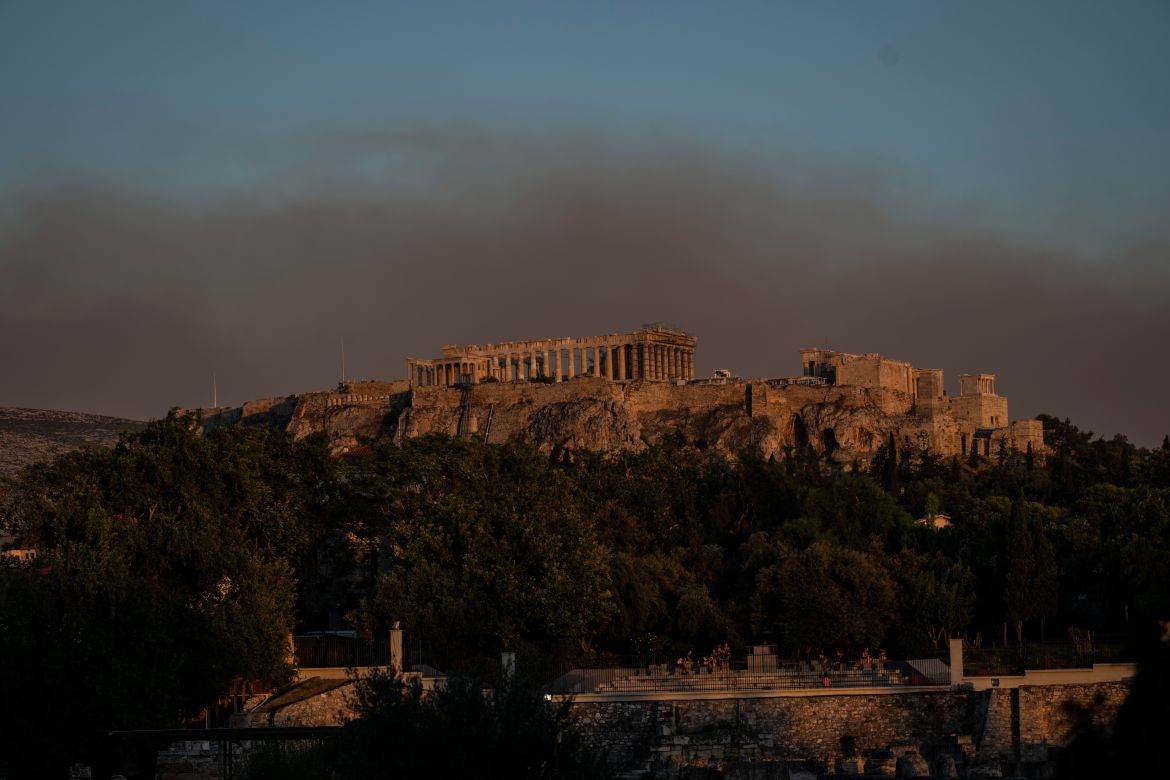 Smoke from a fire blanketed part of the Athenian sky as it is seen behind the ancient Acropolis hill with the Parthenon temple