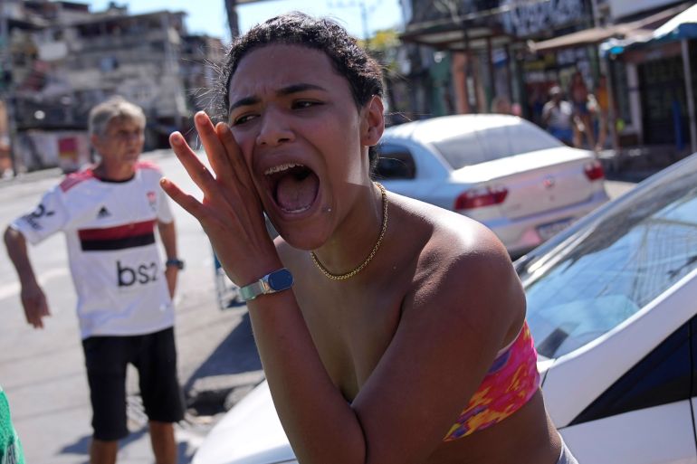 A woman shouts after a police raid in a Rio favela.