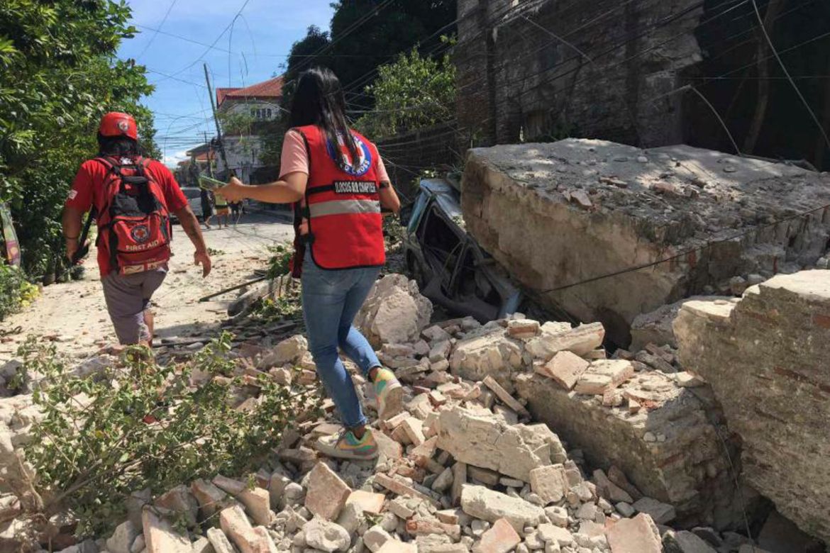 Philippine Red Cross, Red Cross volunteers walk along a collapsed wall