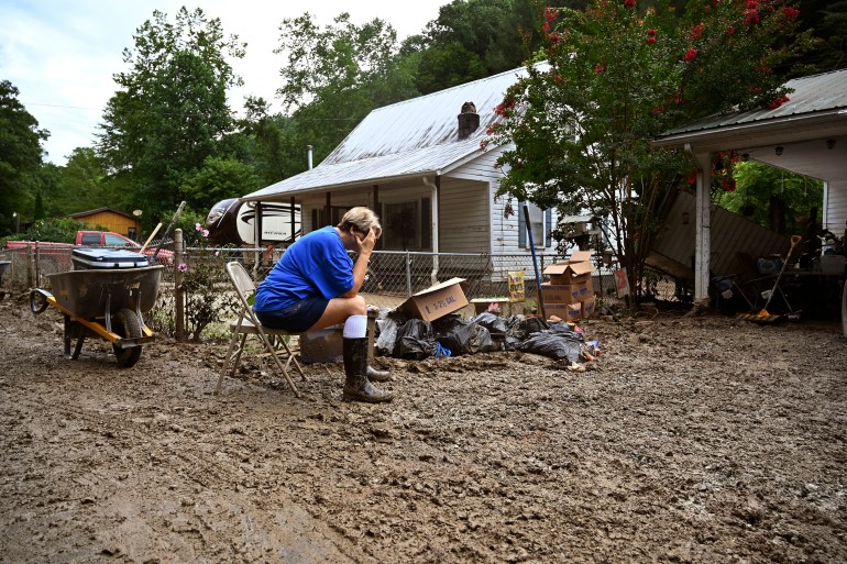 Teresa Reynolds sits exhausted as members of her community clean the debris from their flood ravaged homes at Ogden Hollar in Hindman