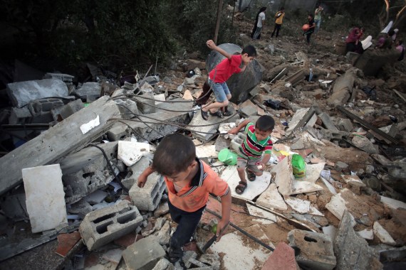 Palestinian children walk in the rubble of a house destroyed by an Israeli strike, in the town of Beit Hanoun, northern Gaza Strip in 2014 [