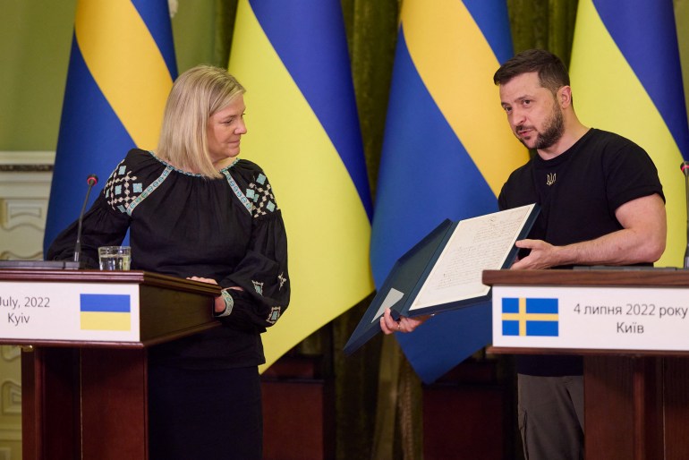 Ukrainian President Volodymyr Zelensky presents a letter from Swedish Prime Minister Magdalena Anderson to his King Charles during a press conference in Kyiv, Ukraine, July 4, 2022 