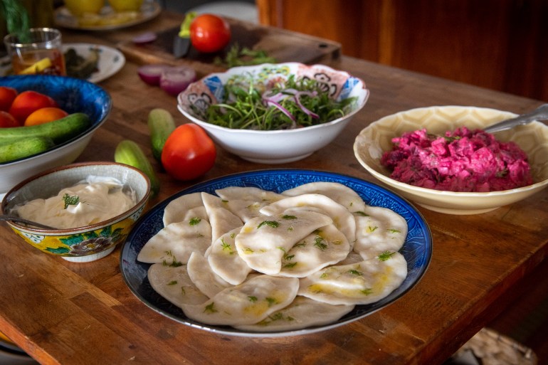 A side view of a table laden with dumplings and other side dishes