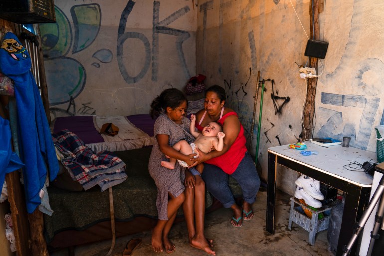 Ana Paula holds one of her children inside her new home