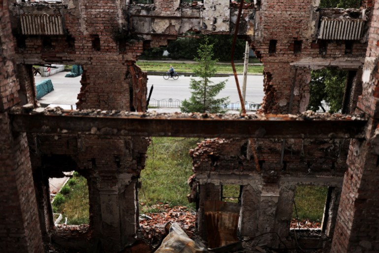 A man rides his bicycle in front of school 134 destroyed in a military attack in Kharkiv, Ukraine July 14, 2022