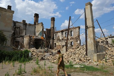 A resident walks near the ruins of a destroyed apartment building in the city of Lysychansk, Ukraine.