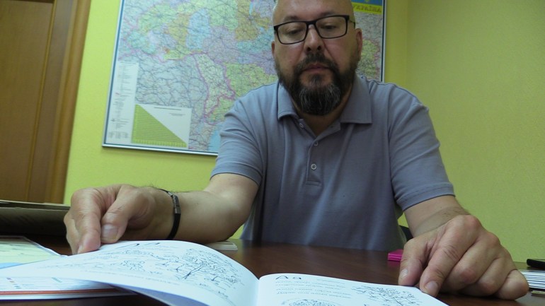 Ο γλωσσολόγος Oleksandr Rybalko δείχνει ένα βιβλίο για την ελληνική διάλεκτο που ομιλείται στην Ουκρανία [Mansur Mirovalev/Al Jazeera]