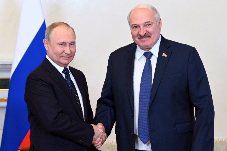 Russian President Vladimir Putin, left, and Belarusian President Alexander Lukashenko shake hands during their meeting in St. Petersburg, Russia, Saturday