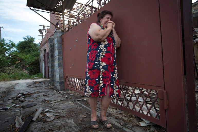 Yekaterina Len, 61, cries outside her ruined house following a shelling in Slovyansk, eastern Ukraine, Tuesday, May 20, 2014