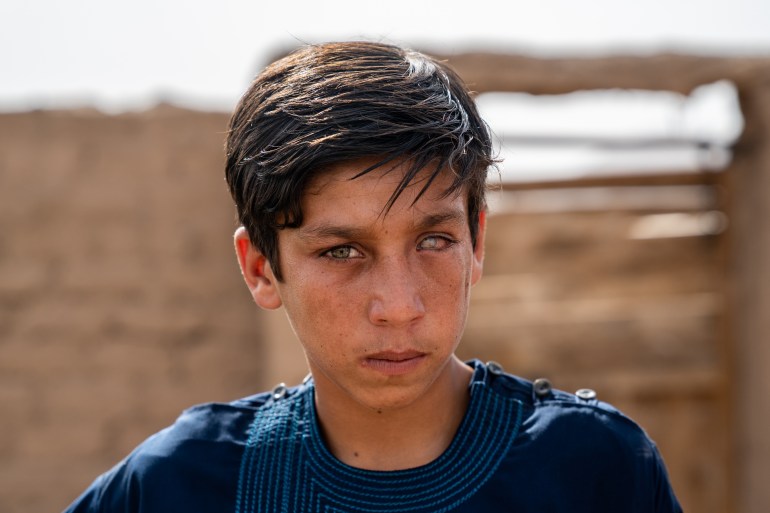 A young Afghan boy outside his home