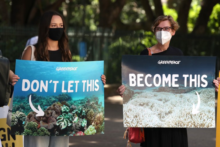 Protesters hold placards pointing to the beauty of the Great Barrier Reef and how climate change could destroy it.