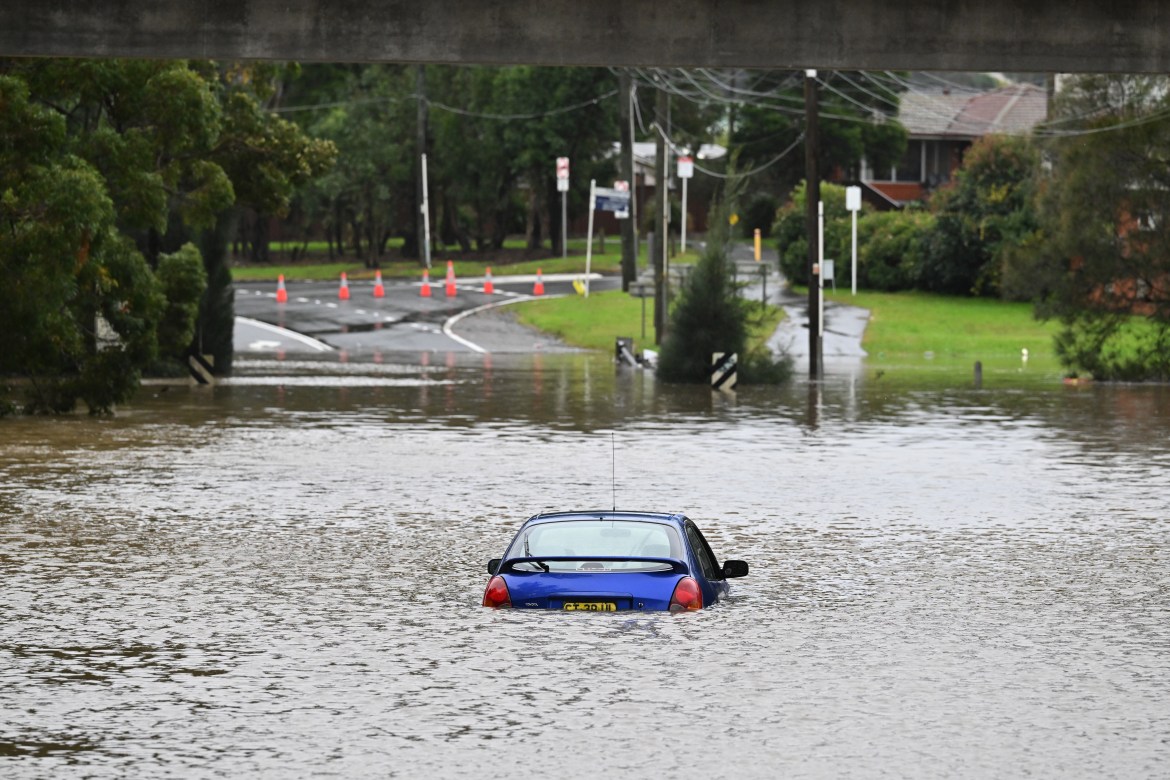 A car is seen abandoned in floodwaters in Lansvale