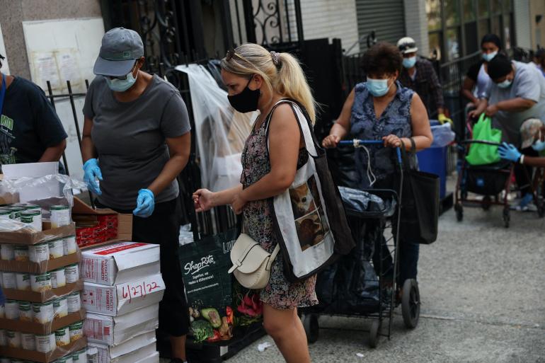 People receive food donations from a food pantry outside a church on the Grand Concourse in the Bronx borough of New York City, U.S.