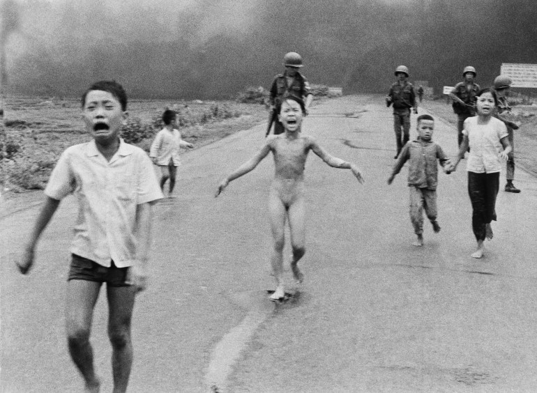 Nine-year-old Kim Phuc, centre, runs with her brothers and cousins, followed by South Vietnamese forces, down Route 1 near Trang Bang