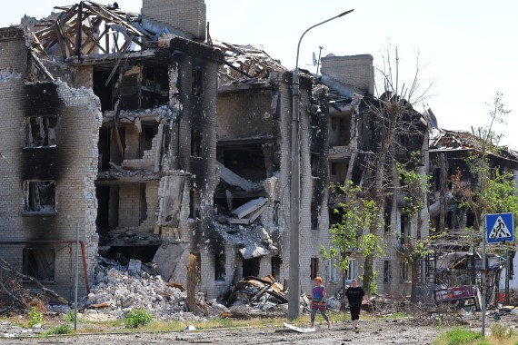 Local residents walk past apartment buildings destroyed during Ukraine-Russia conflict in the city of Severodonetsk in the Luhansk Region, Ukraine June 30, 2022
