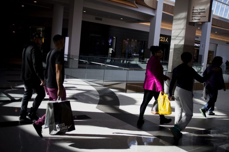Shoppers carry bags while walking at the Roosevelt Field Mall in Garden City, New York.