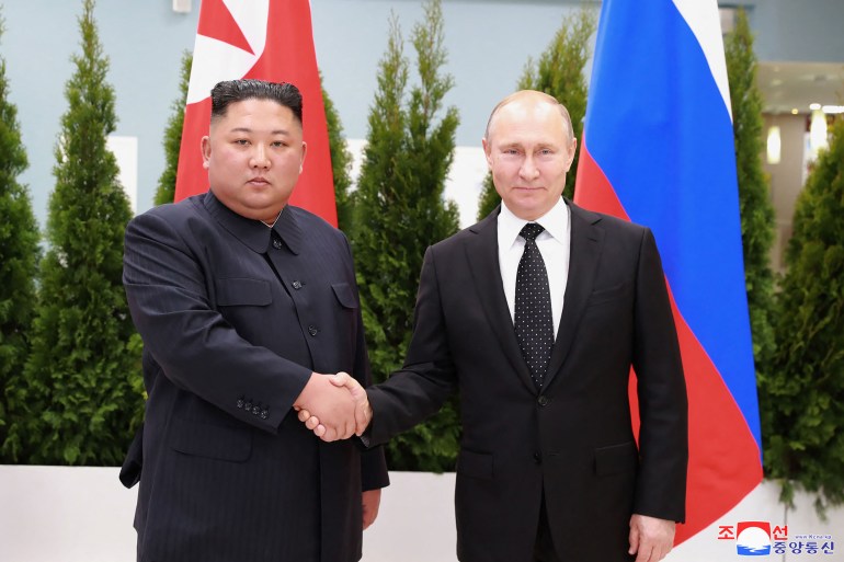Russian President Vladimir Putin and North Korean leader Kim Jong Un shake hands as they pose for pictures prior to their talks in Russia in 2019