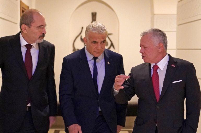This handout picture released by the Jordanian Royal Palace shows Jordan's King Abdullah II (R) and Jordan's Foreign Minister Ayman Safadi (L) receiving Israeli Prime Minister Yair Lapid at al-Husseiniya Palace in Amman