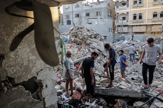 Palestinians assess the damage in a building