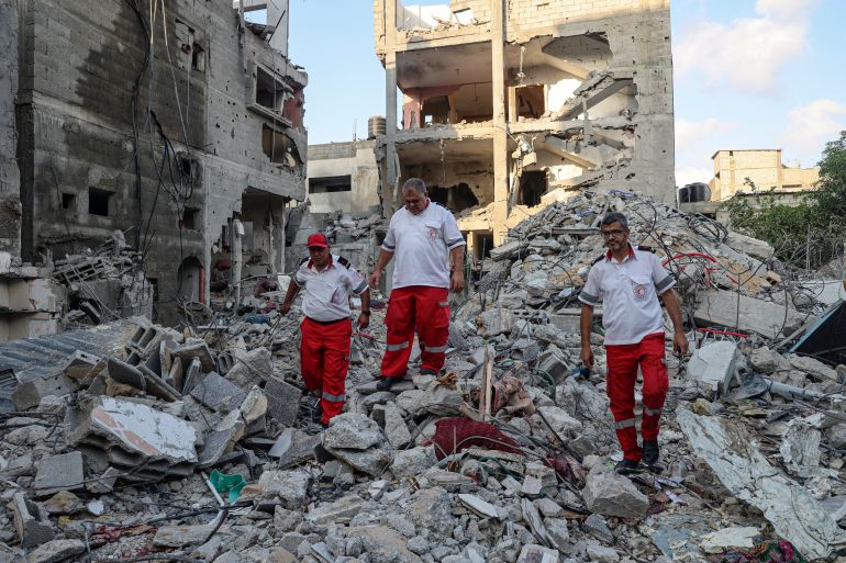 Rescuers walk amid the rubble of a building destroyed by Israeli air raids in Gaza.