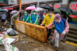 Workers clear debris at the historic Namseong Market in Seoul&#39;s Gangnam district after record-breaking rains caused severe flooding [Anthony Wallace/ AFP]