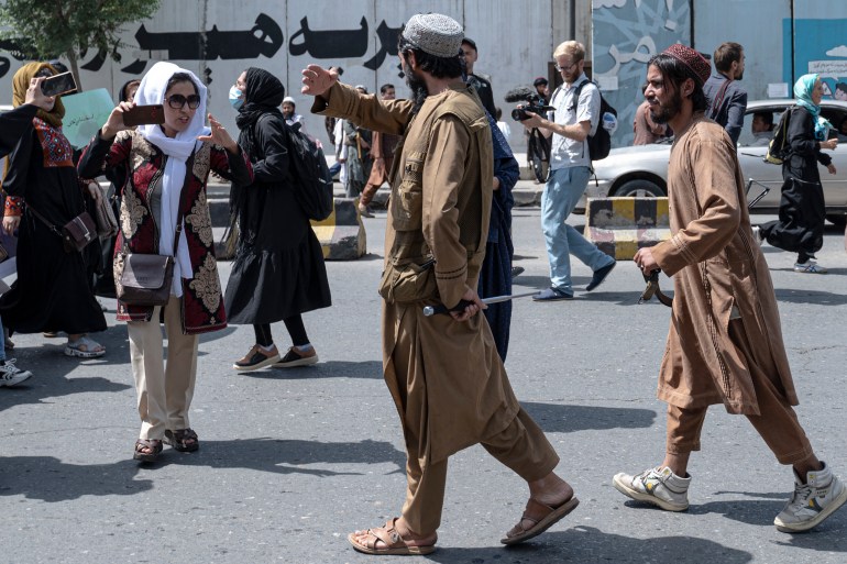 Taliban fighters disperse Afghan women protesters in Kabul.