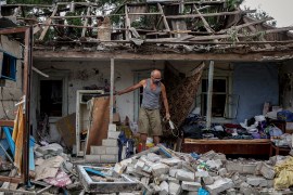 A man collects belongings from his destroyed house after a missile attack in the town of Kramatorsk, in the Donetsk region [File: Anatolii Stepanov / AFP]