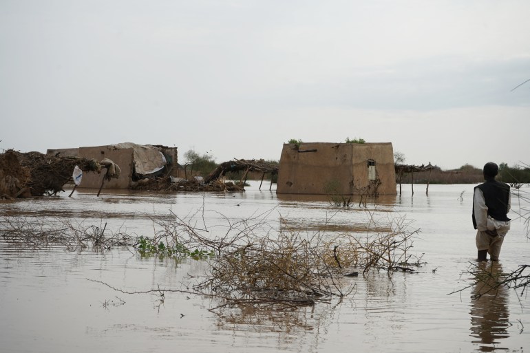 A Sudanese man walks through a flooded area near al-Qash river on August 18, 2022 in Aroma, in the eastern state of Kassala, one of the badly affected regions in Sudan due to torrential rains this week. - The death toll from flooding has risen to more than 75 with heavy rain damaging tens of thousands of homes, according to police earlier this week, even though torrential rains usually fall in Sudan between May and October, when the country faces severe flooding, wrecking property, infrastructure and crops. (Photo by Hussein ERY / AFP)