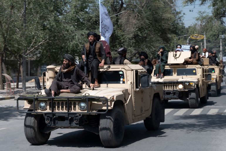 Taliban fighters parade on humvee vehicles