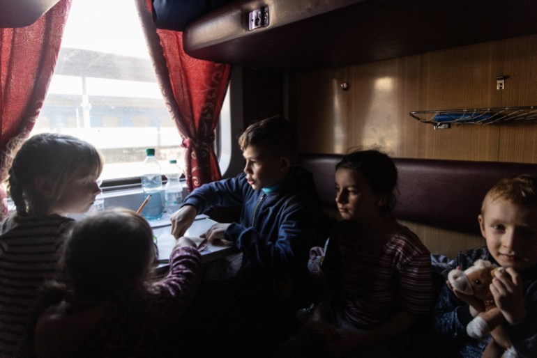A photo of children sitting on a train.