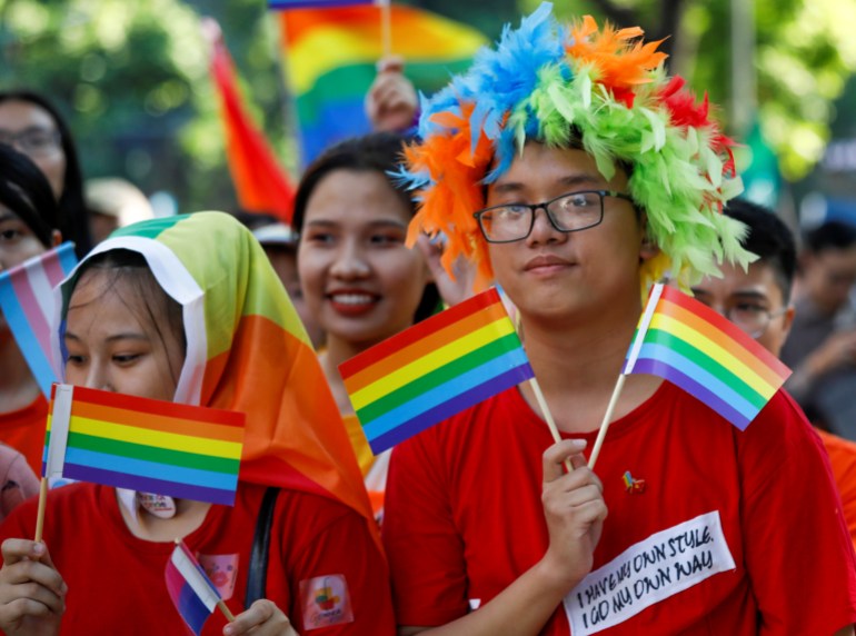 Revellers at Hanoi Pride wear rainbow wigs and carry rainbow flags