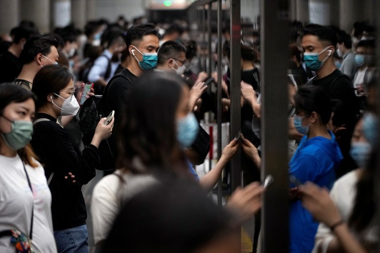 Commuters crowded together on the platform during rush hour in Shanghai