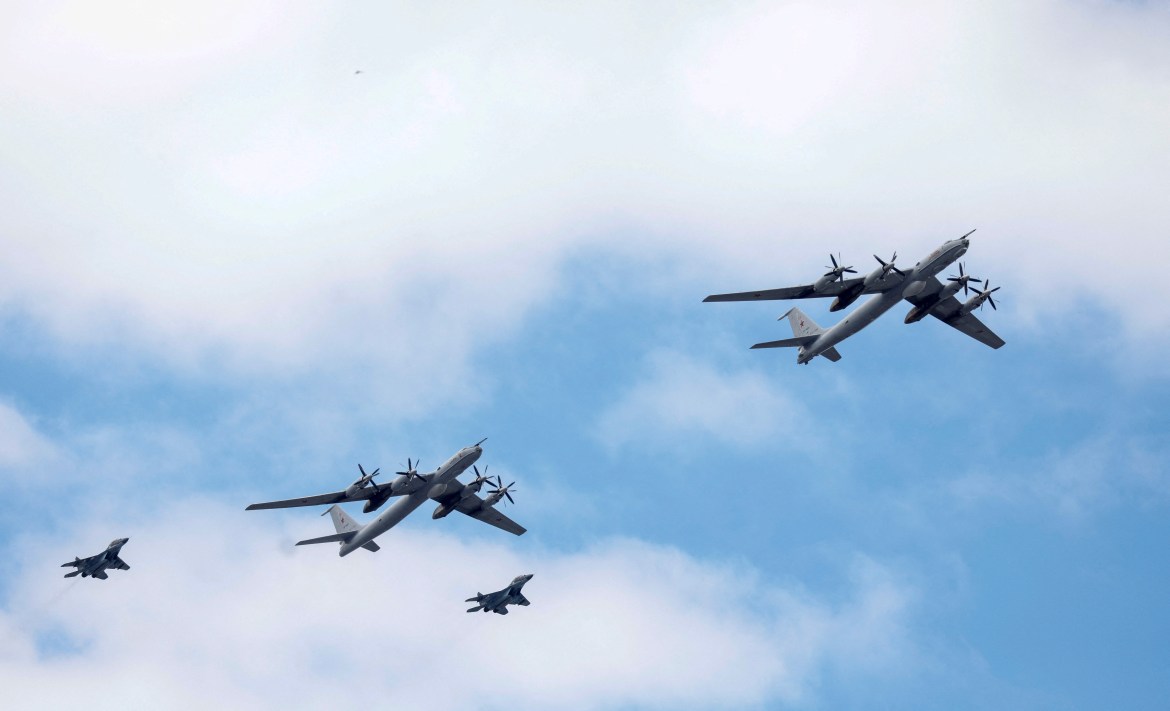 Russian military planes, including Tu-142 maritime reconnaissance and anti-submarine aircraft, fly in formation during a parade marking Navy Day in Saint Petersburg