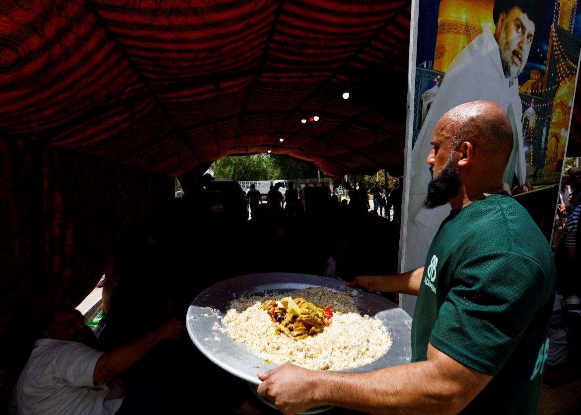 An Iraqi man distributes free meals for supporters