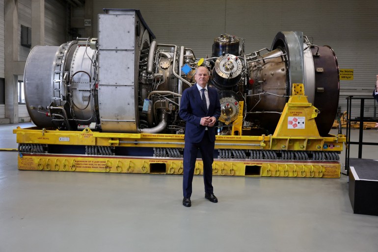 Olaf Scholz stands next to a gas turbine