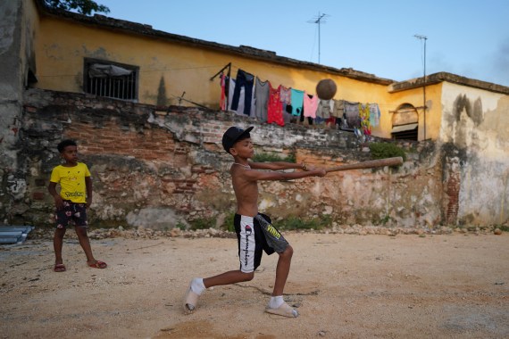 Kevin Kindelan (L), 8, plays baseball with friends at a vacant lot in Havana