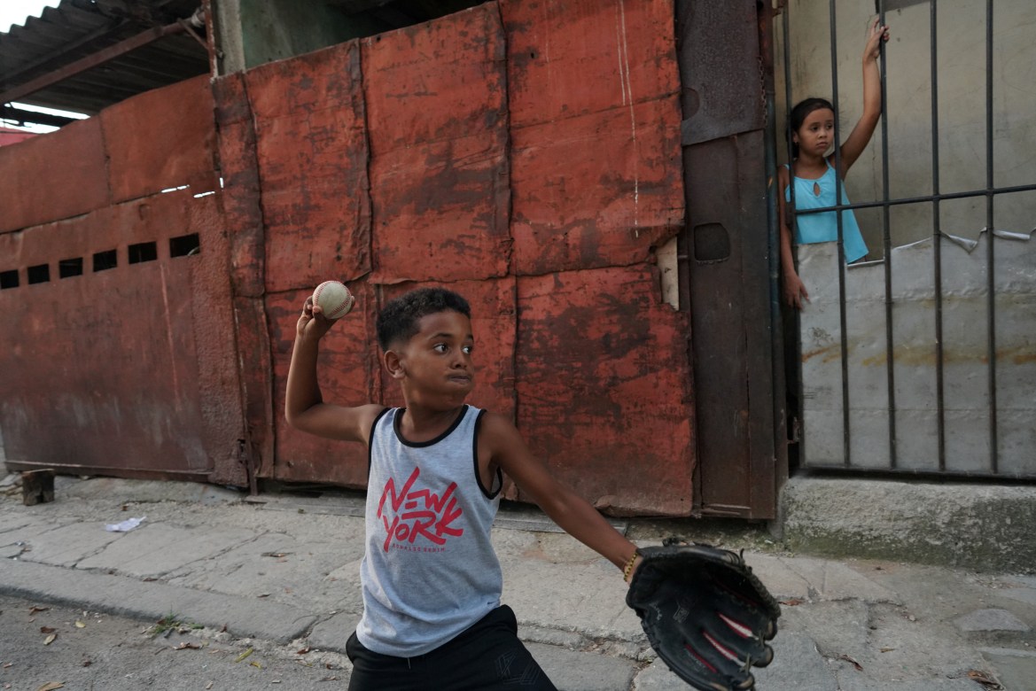 Kevin Kindelan, 8, practices baseball in front of his house in Havana