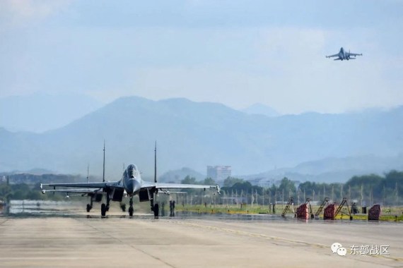 Chinese fighters jets - one on the runway and one in the air - at an undisclosed location during drills around Taiwan