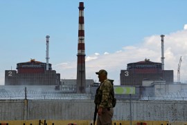 A serviceman with a Russian flag on his uniform stands guard near the Zaporizhzhia Nuclear Power Plant [File:Reuters]