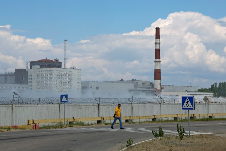 A man crosses a road near the Zaporizhzhia Nuclear Power Plant in the course of Ukraine-Russia conflict outside the Russian-controlled city of Enerhodar in the Zaporizhzhia region.