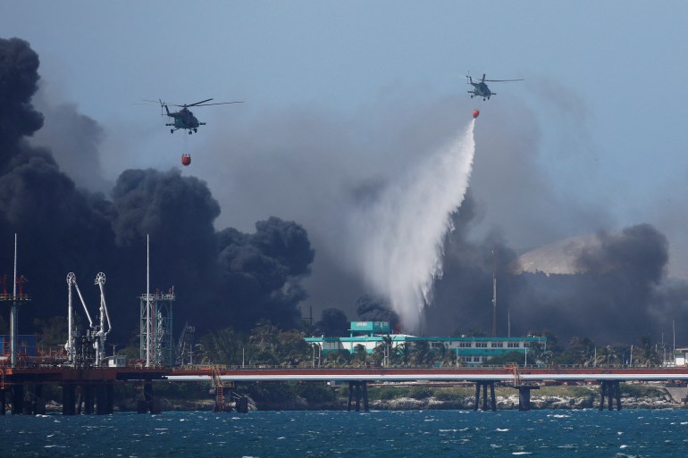 Helicopters throw water over fuel storage tanks on fire near Cuba's supertanker port in Matanzas, Cuba.