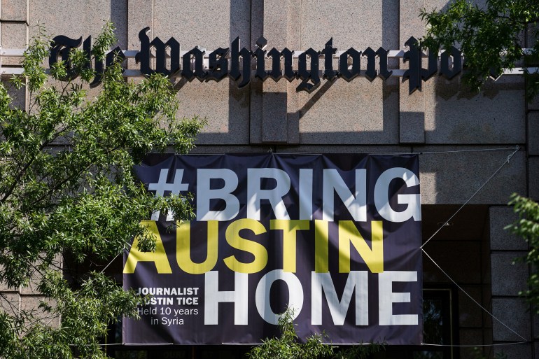 Un semn #BringAustinHome este văzut în clădirea Washington Post