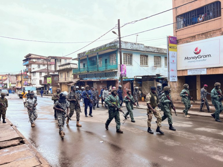 Riot police members patrol the street during anti-government protests in Freetown, Sierra Leone
