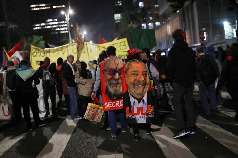 Brazilian protesters carry towels of Lula at a protest for democracy