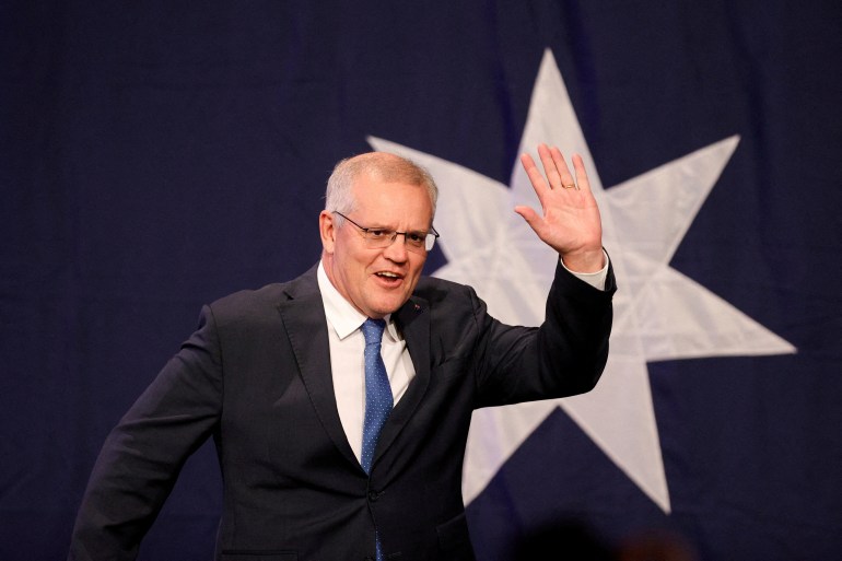 Scott Morrison acknowledging supporters in front of a star from the Australian flag