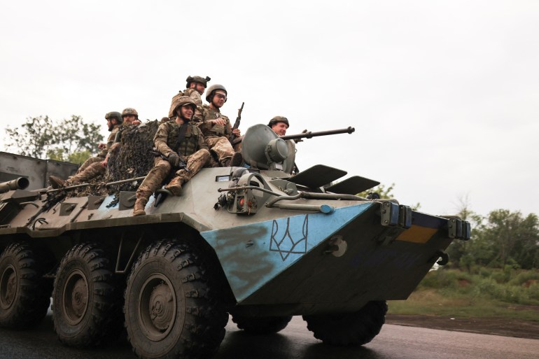 Ukrainian servicemen travel on a Wheeled-BTR fighting vehicle near Bakhmut.