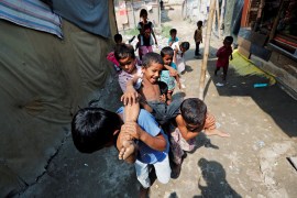 Rohingya children play outside their shacks in a camp in New Delhi [File: Adnan Abidi/Reuters]