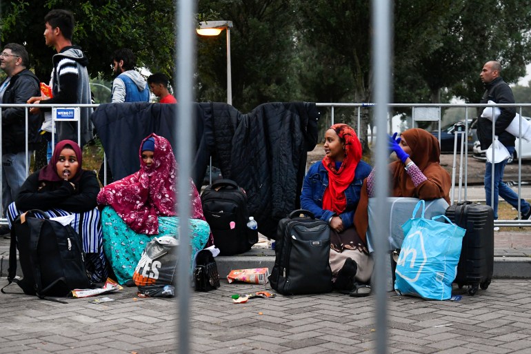 Vluchtelingen wachten buiten op de natte grond bij het hoofdopvangcentrum voor asielzoekers, in Ter Apel, Nederland, 17 augustus 2022. Meer dan honderd mensen brachten nachten buiten door, slapend aan de kant van de weg met weinig of geen onderdak of voedsel Absoluut.  Foto: Berrochka van de Wou/Reuters