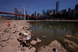 A boy climbs on a dried-up riverbed of the Jialing river, a tributary of the Yangtze, that is approaching record low water levels in Chongqing, China [File: Thomas Peter/Reuters]